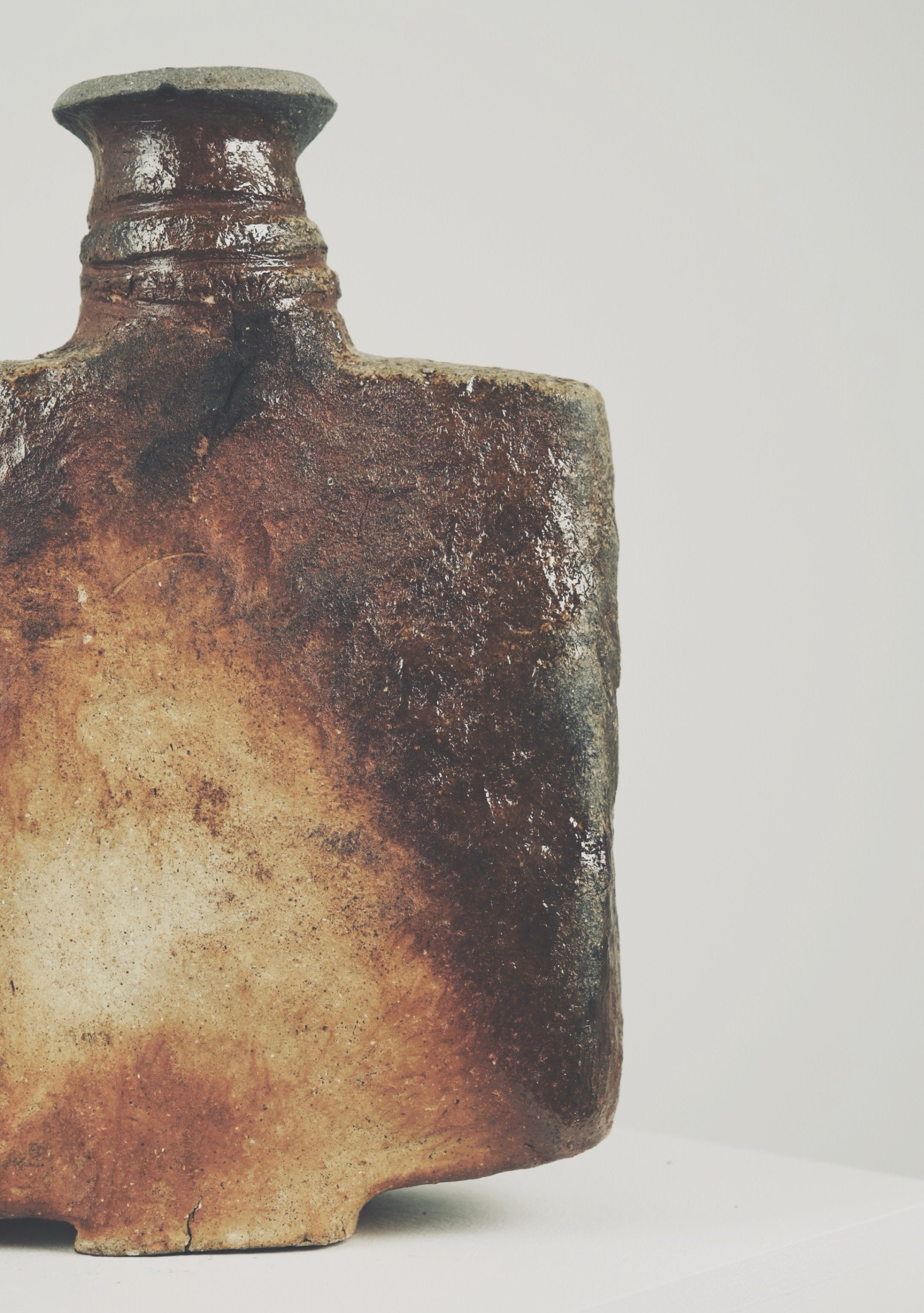 Weathered ceramic bottle detail showing aged patina and textured surface
