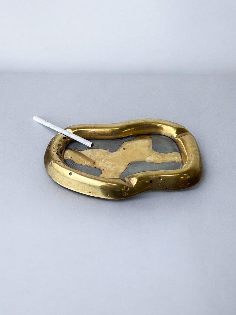 Brutalist ashtray by David Marshall, Spain, 70's — close-up of brass surface with cigarette