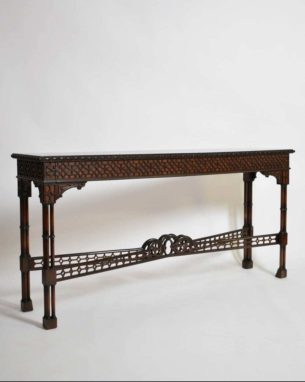 The Carved Wood Console Table, XIXth c. by Barracuda Interiors features intricate geometric carvings, four slender legs, and a decorative stretcher—evoking 19th-century elegance against a plain white background.
