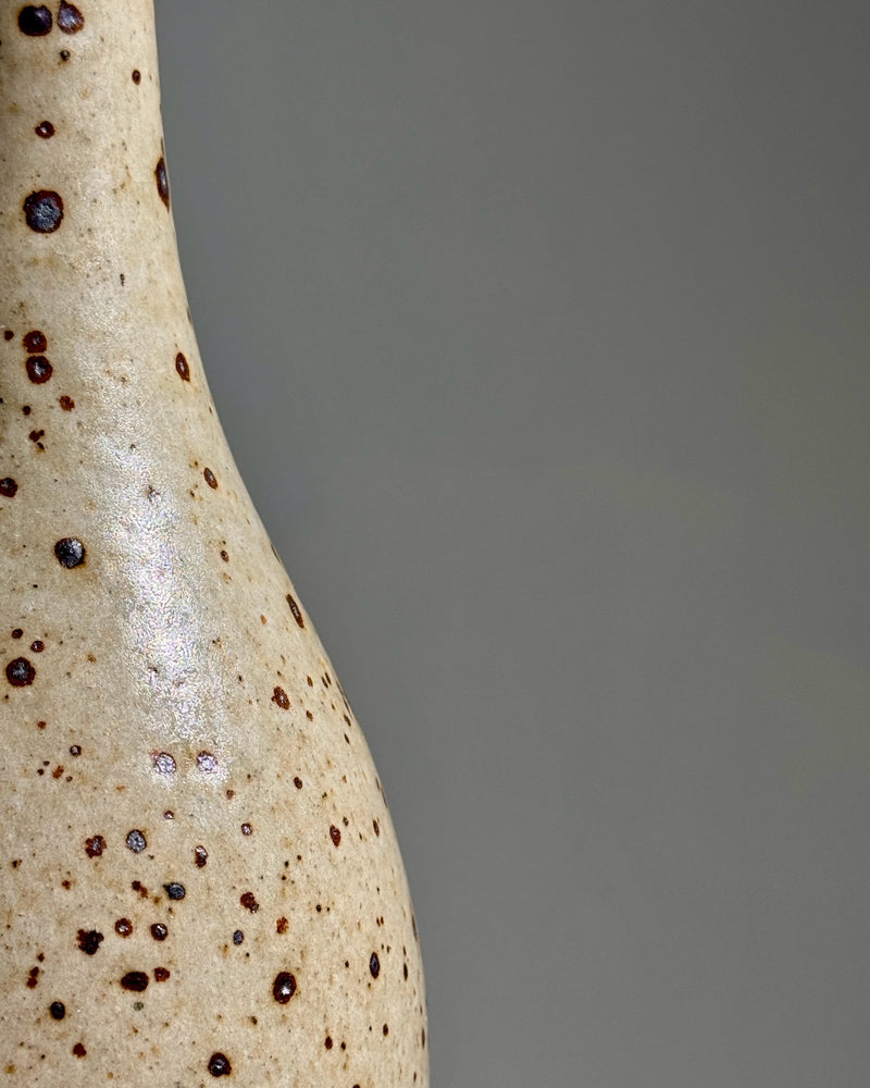 Close-up detail of speckled stoneware vase with dark iron spots