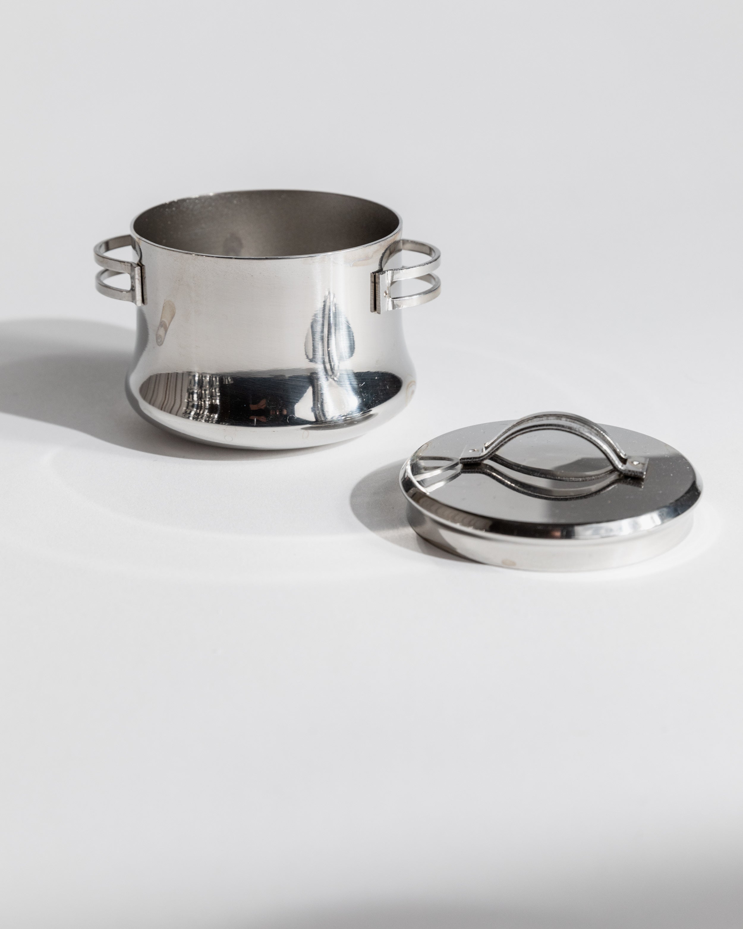 Stainless steel coffee pot and lid separated showing interior detail