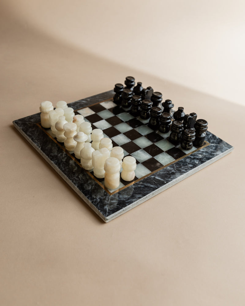 Vintage marble chess set with carved pieces on checkered stone board