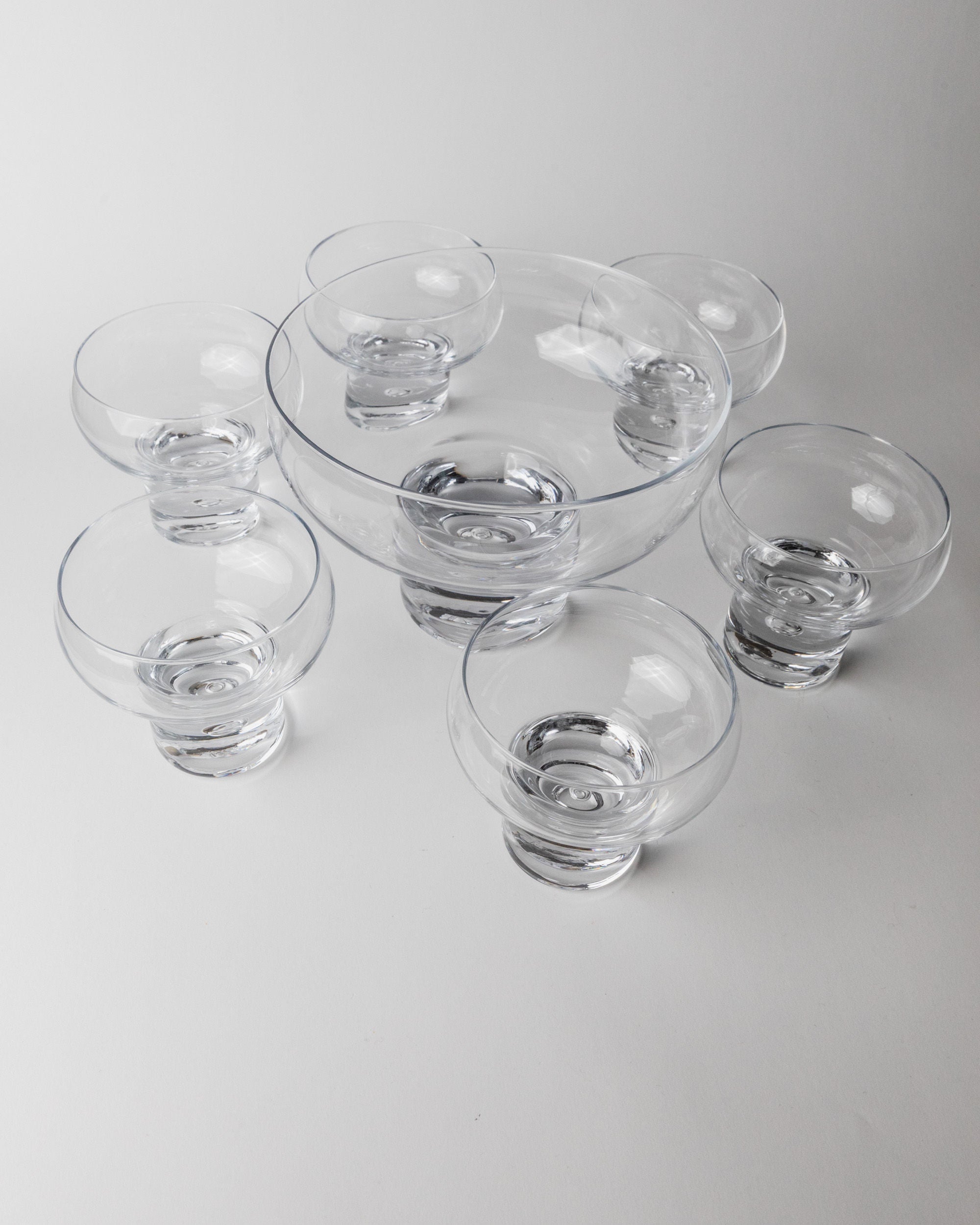 Set of 6 Glasses and 1 Bowl by Vicke Lindstrand, Italy 1960s — overhead view of clear glass drinkware set