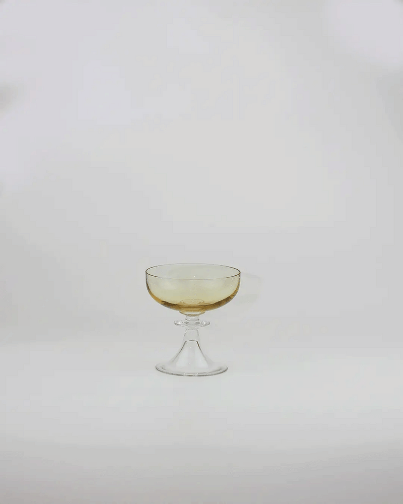 Amber crystal cocktail coupe with clear stem on white background