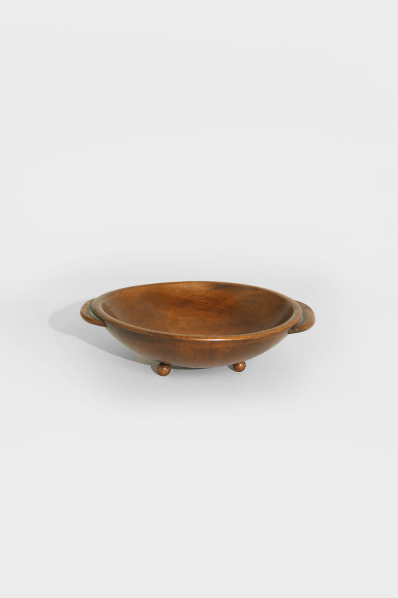 Folk wooden bowl with handles and ball feet, angled view