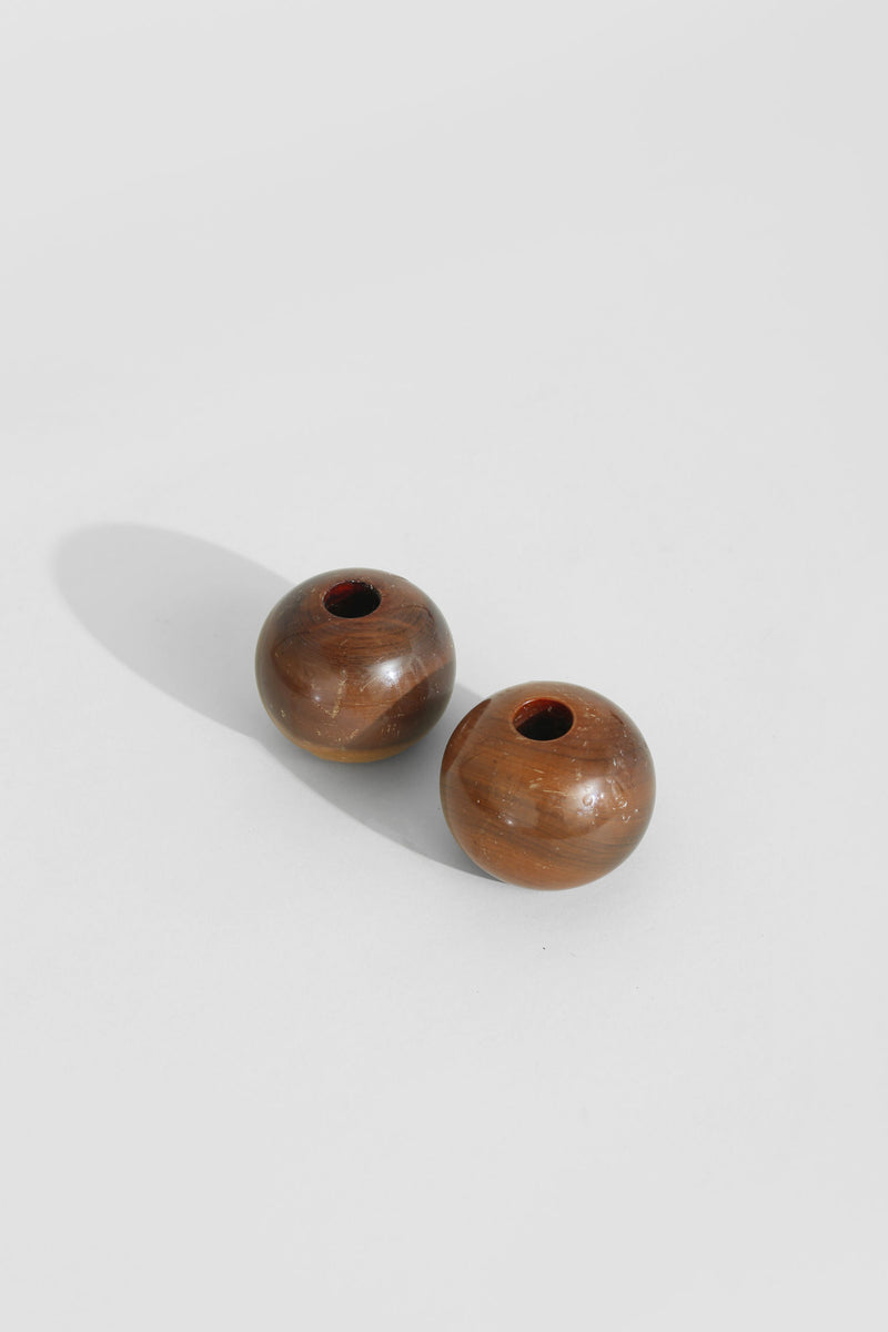 Two spherical wooden candleholders with natural grain finish