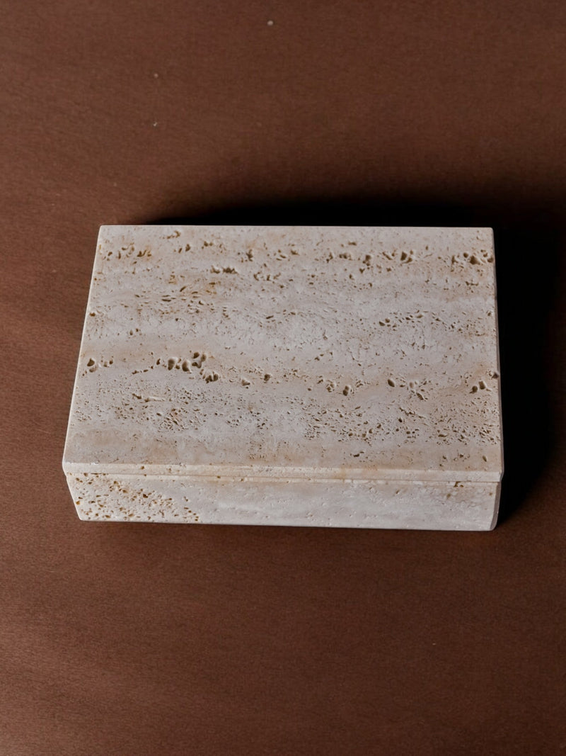 Travertine brutalist box surface texture detail showing natural stone pores