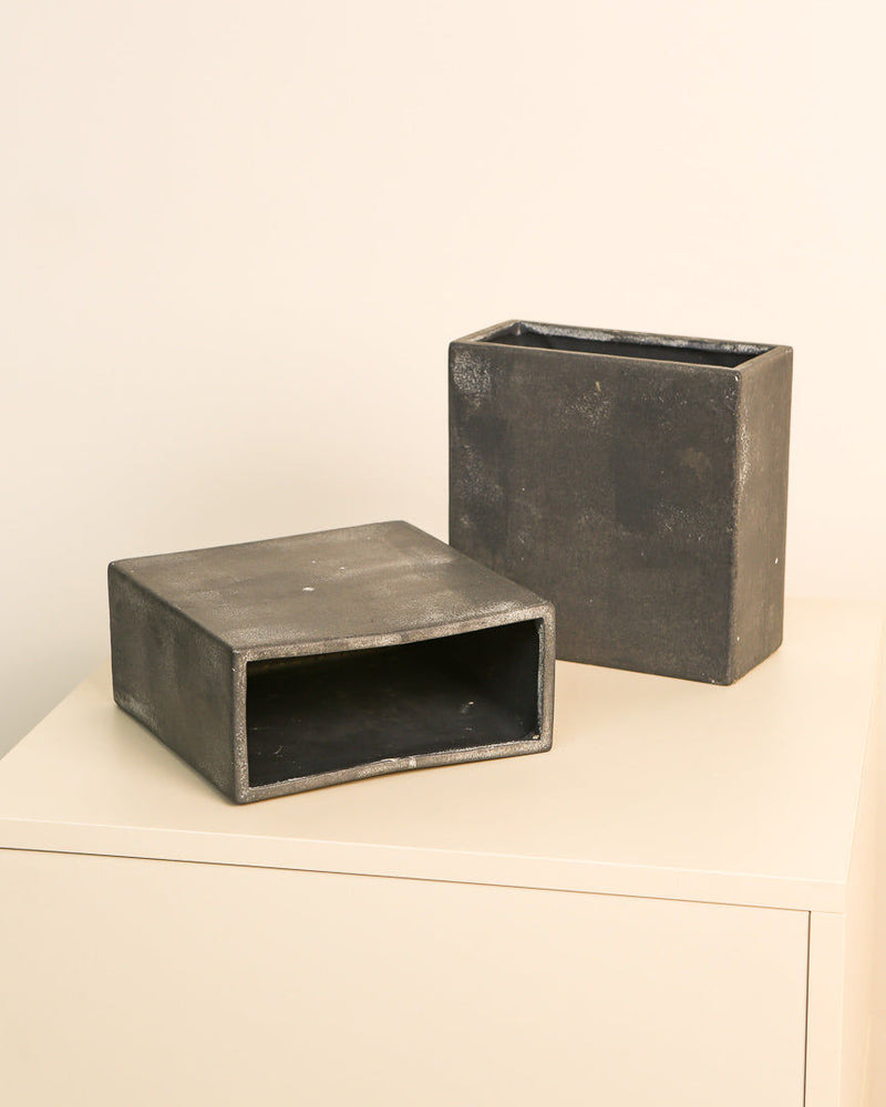 Pair of gunmetal Italian sheet metal vases styled on white surface