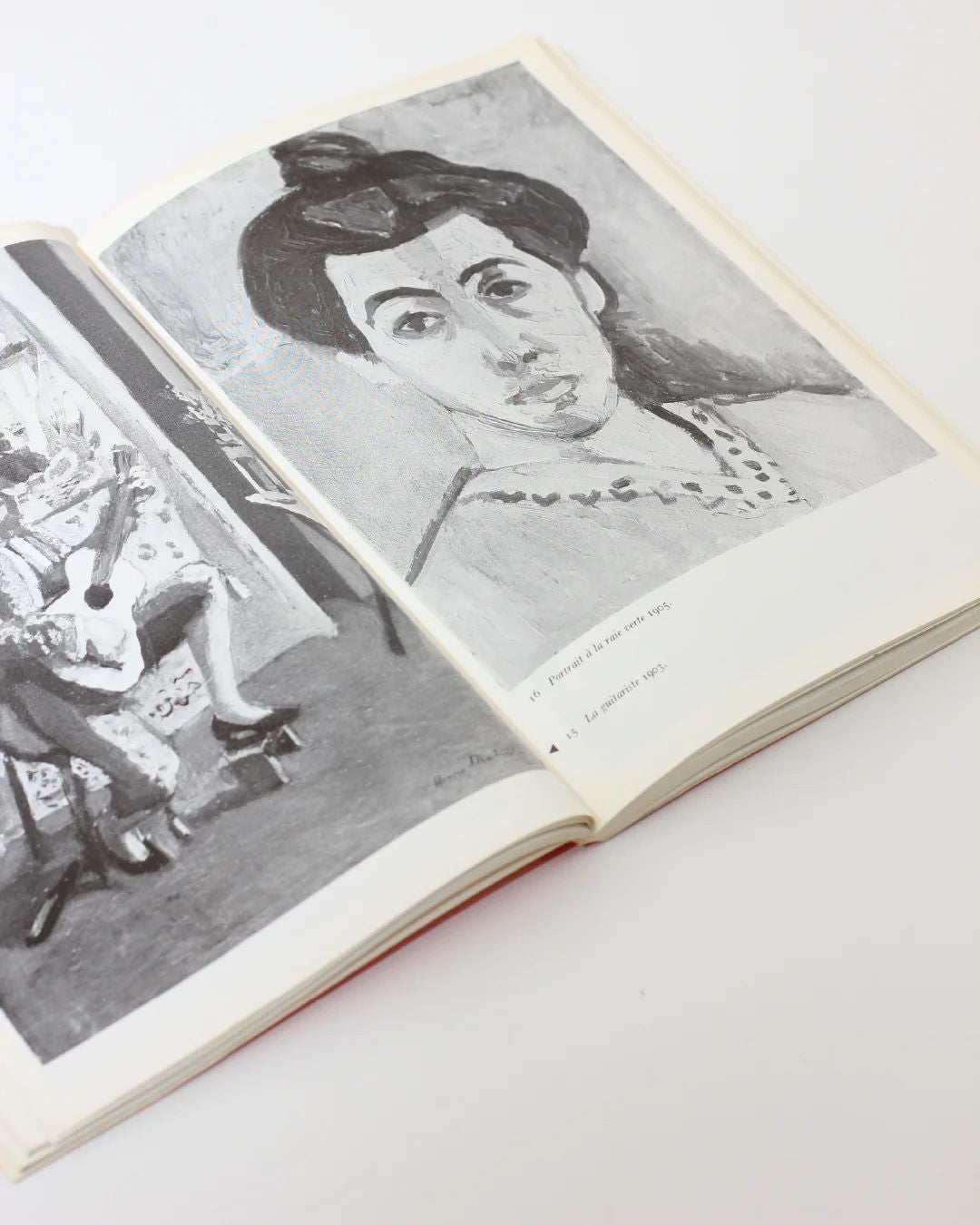 The Matisse on Art Book from Boga Avante Shop showcases modern art with two black and white paintings. The left page depicts a guitarist, echoing Matisse's fluid style, and the right displays a woman with a bun, elegantly resting on a white surface.