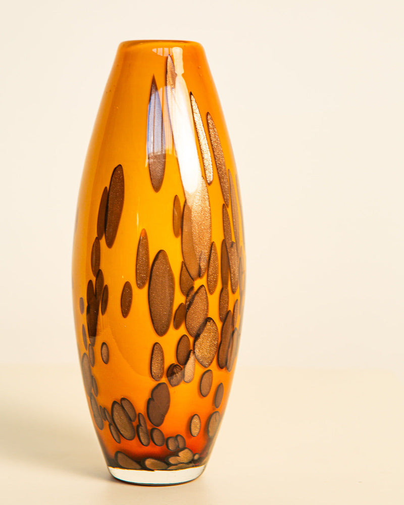 The Murano Blown Glass Vase 80s by Treaptyque is a tall, oval vase with a glossy finish, an orange base, and brown abstract spots, capturing the vibrant spirit of Italian glass art against a plain light background.