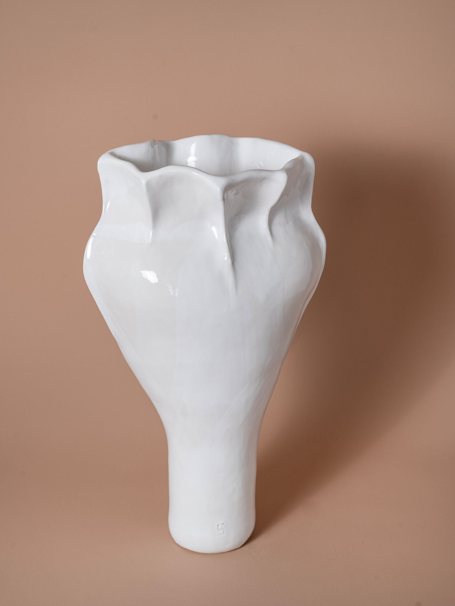 The Seed of Light Form Vase 14 from Siham Djebbar Ceramics' Seed Series is a glossy white handcrafted stoneware vase with an irregular sculpted shape and wavy rim, shown against a plain beige background.