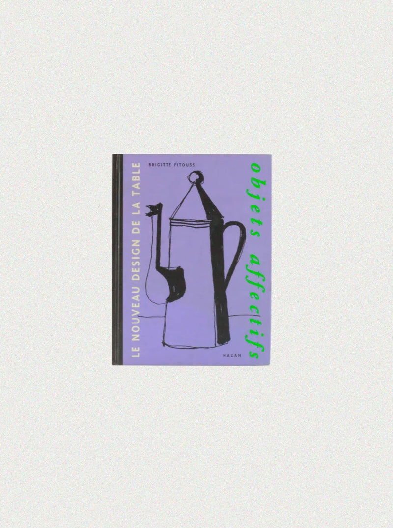 A book cover titled "Objets Affectifs: Le Nouveau Design de la Table" by Brigitte Fitoussi, featuring a minimalistic black illustration of kitchenware on a purple background. The text "Le Nouveau Design De La Table" appears in yellow on the spine, showcasing diseño moderno. Available at Boga Avante Shop.