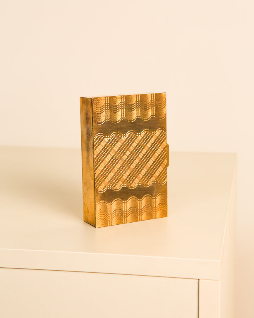 Geometric engraved brass box detail showing decorative surface patterns