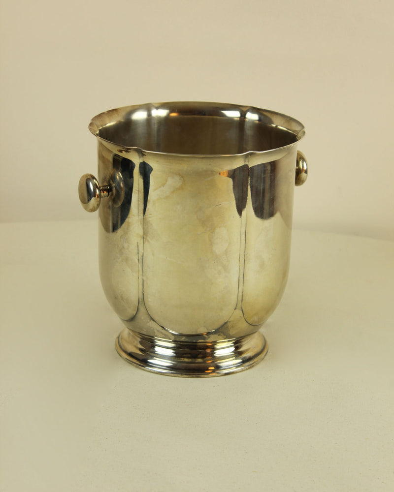 Polished silver-plated ice bucket with twin handles closeup