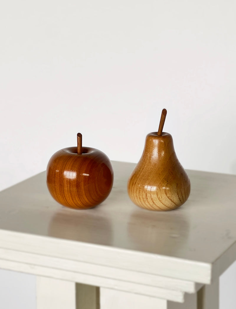 Wooden apple and pear sculptures by David Gliddon on white surface
