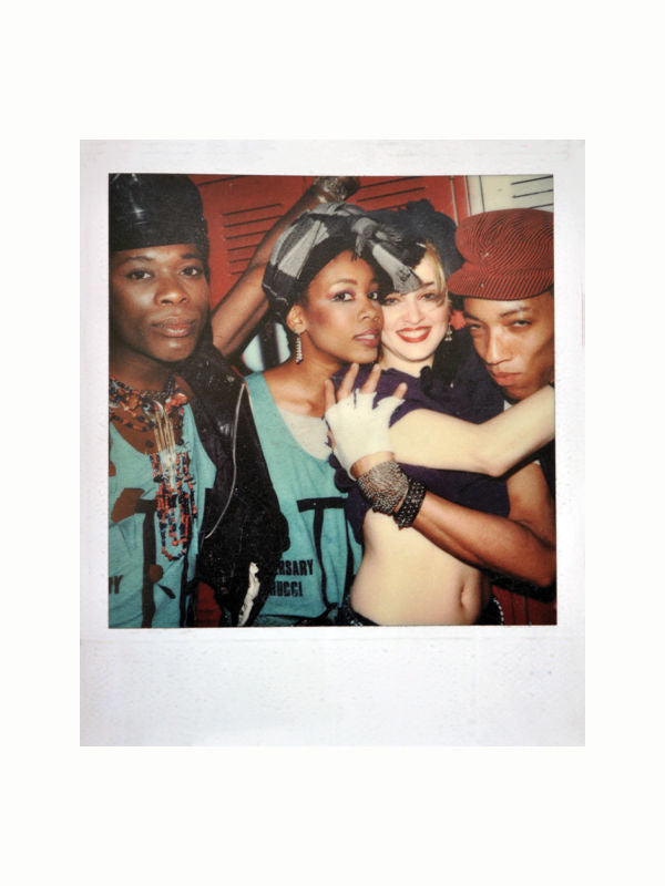 A Maison Plage Fiorucci photo of four people wearing fashionable 80s-style clothing and accessories, reminiscent of a Fiorucci fashion book. They are posing together closely, with one person in the center wrapped in another's arm. They all appear to be enjoying themselves, smiling and interacting with the camera.