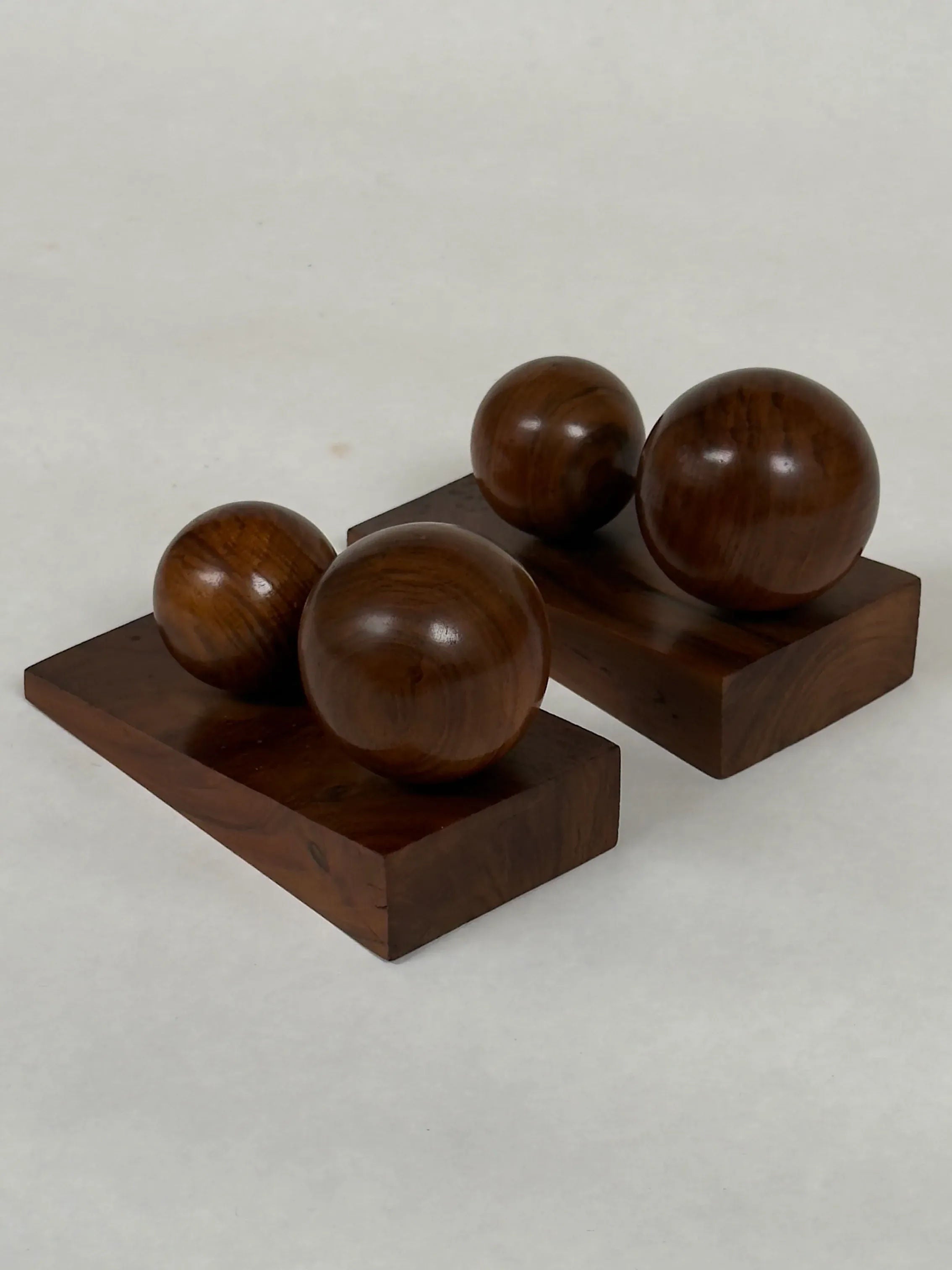 Galerie Storm's Art Deco Bookends in Walnut showcase minimalist geometric design with solid walnut and dark wooden spheres: one bookend with a single sphere, the other holding two on rectangular bases.