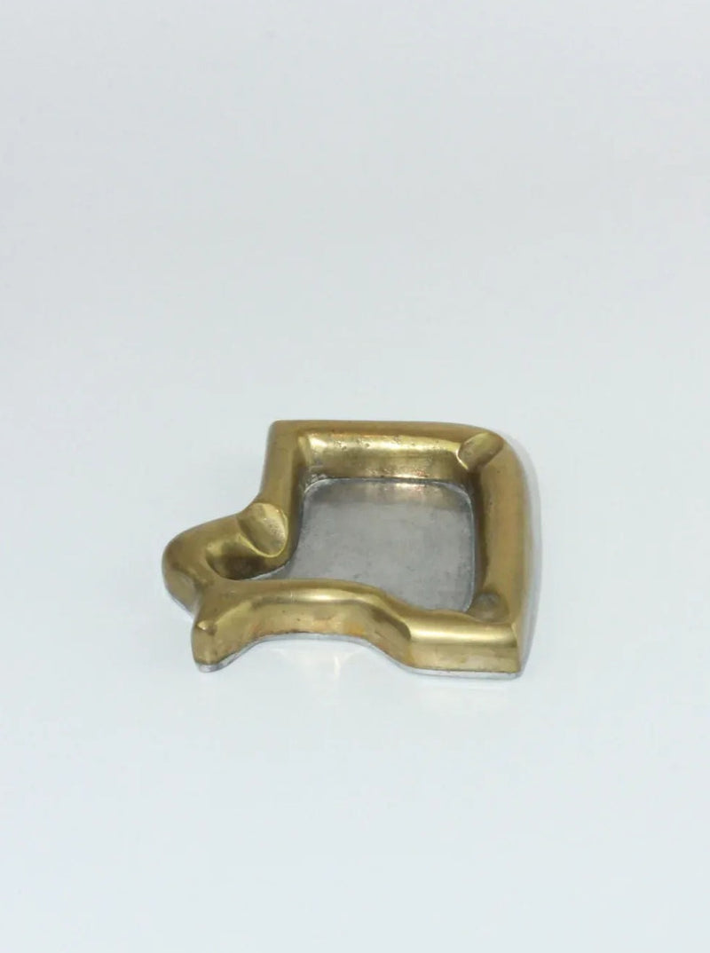 A Brutalist Ashtray with a rectangular shape and slightly curved edges, reminiscent of the clean lines often seen in David Marshall's work from Boga Avante Shop. The ashtray features a central rectangular cutout and a protruding hook on the left side for holding cigarettes. The background is plain white.