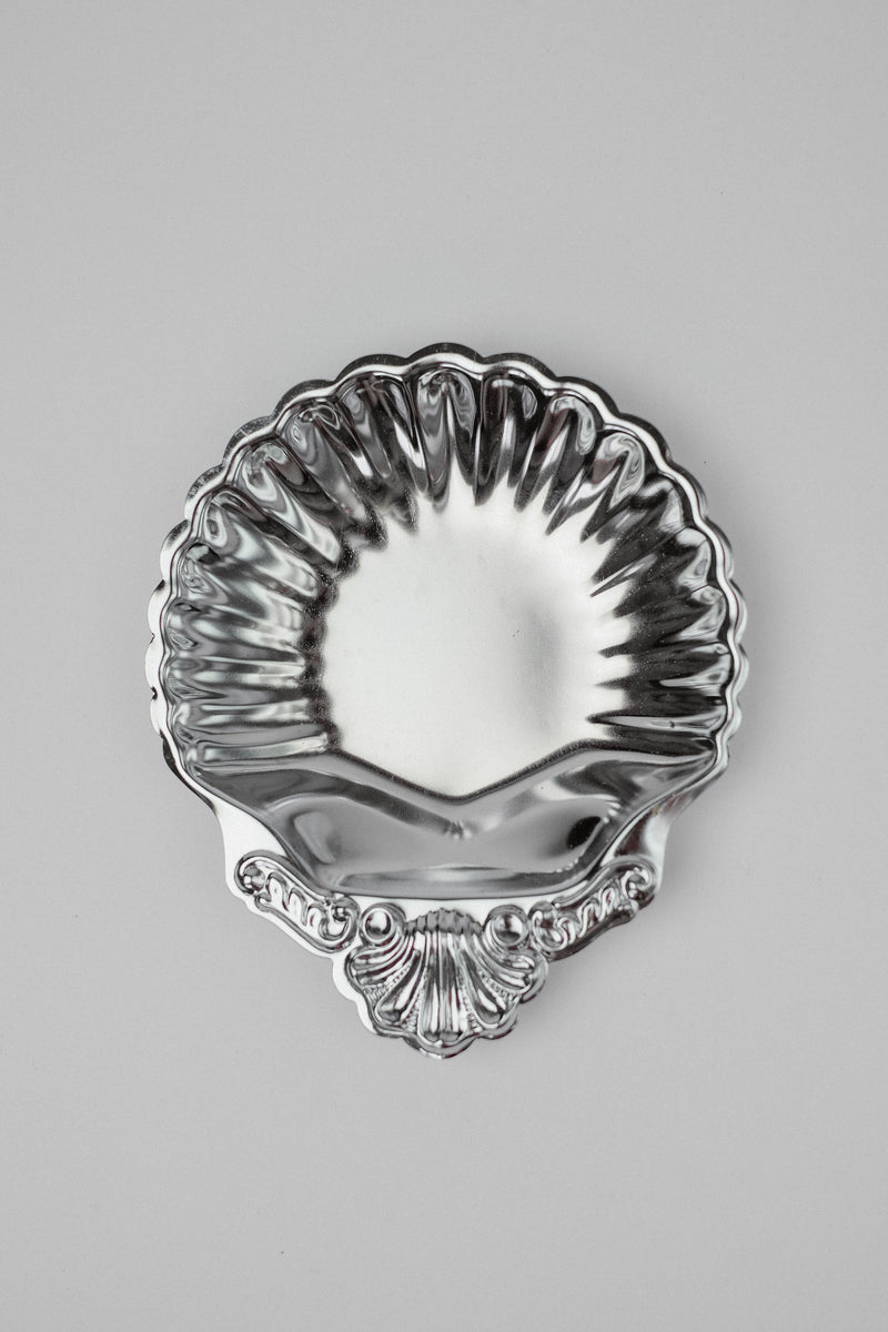 Silver shell-shaped decorative dish with scalloped edges and ornate base