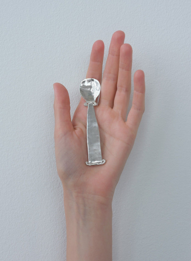 Hand holding Jakob silver spoon showing hammered texture detail