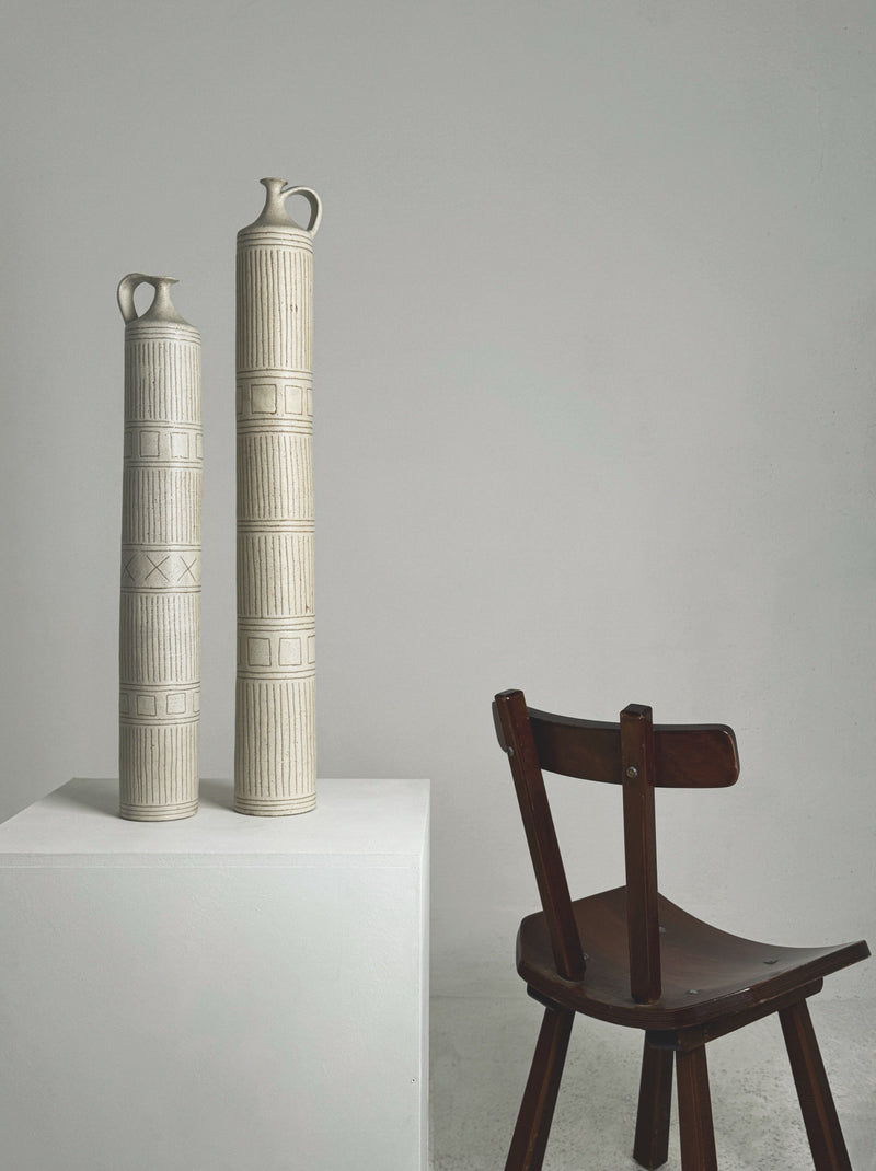 Tall cream ceramic bottles with geometric patterns by Bruno Gambone