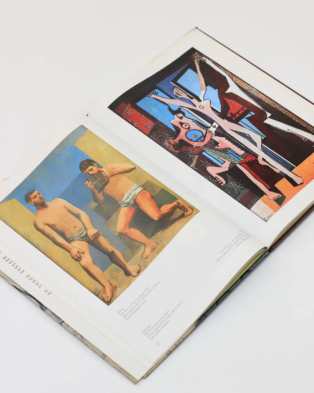 A copy of the "Picasso by Gabriel Potter Vintage Art Book" from Boga Avante Shop displays two pages of modern art: the left page showcases partially dressed figures with a blue and yellow backdrop reminiscent of Picasso, while the right bursts with vibrant abstract shapes and forms that echo the brilliance of Spanish artists.