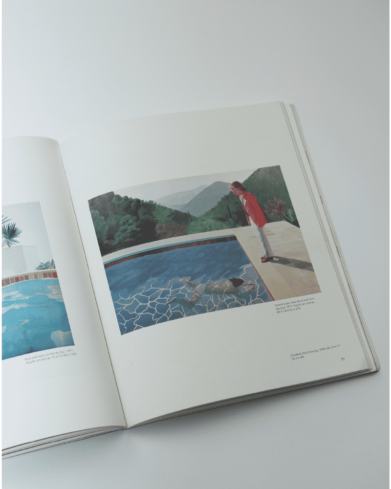 Open David Hockney art book showing pool painting with figure