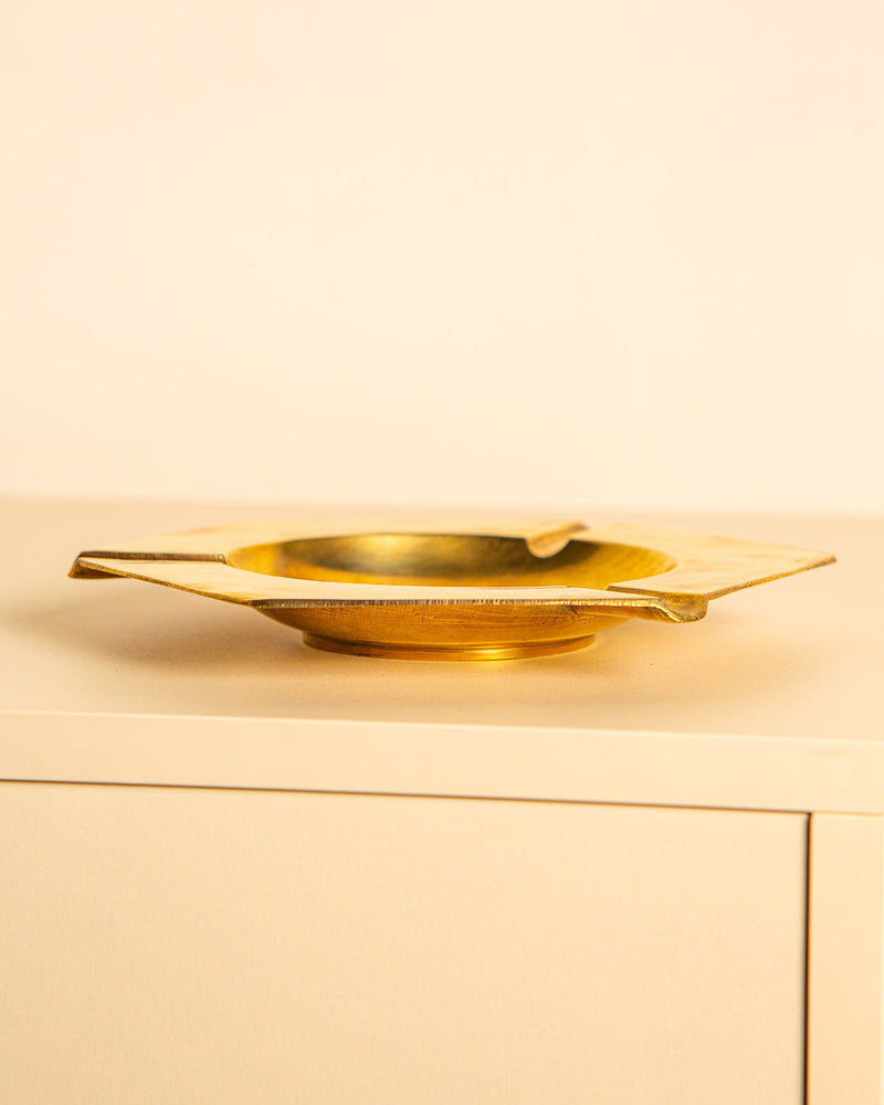 Golden brass ashtray on minimalist cabinet, Italian 1960s design