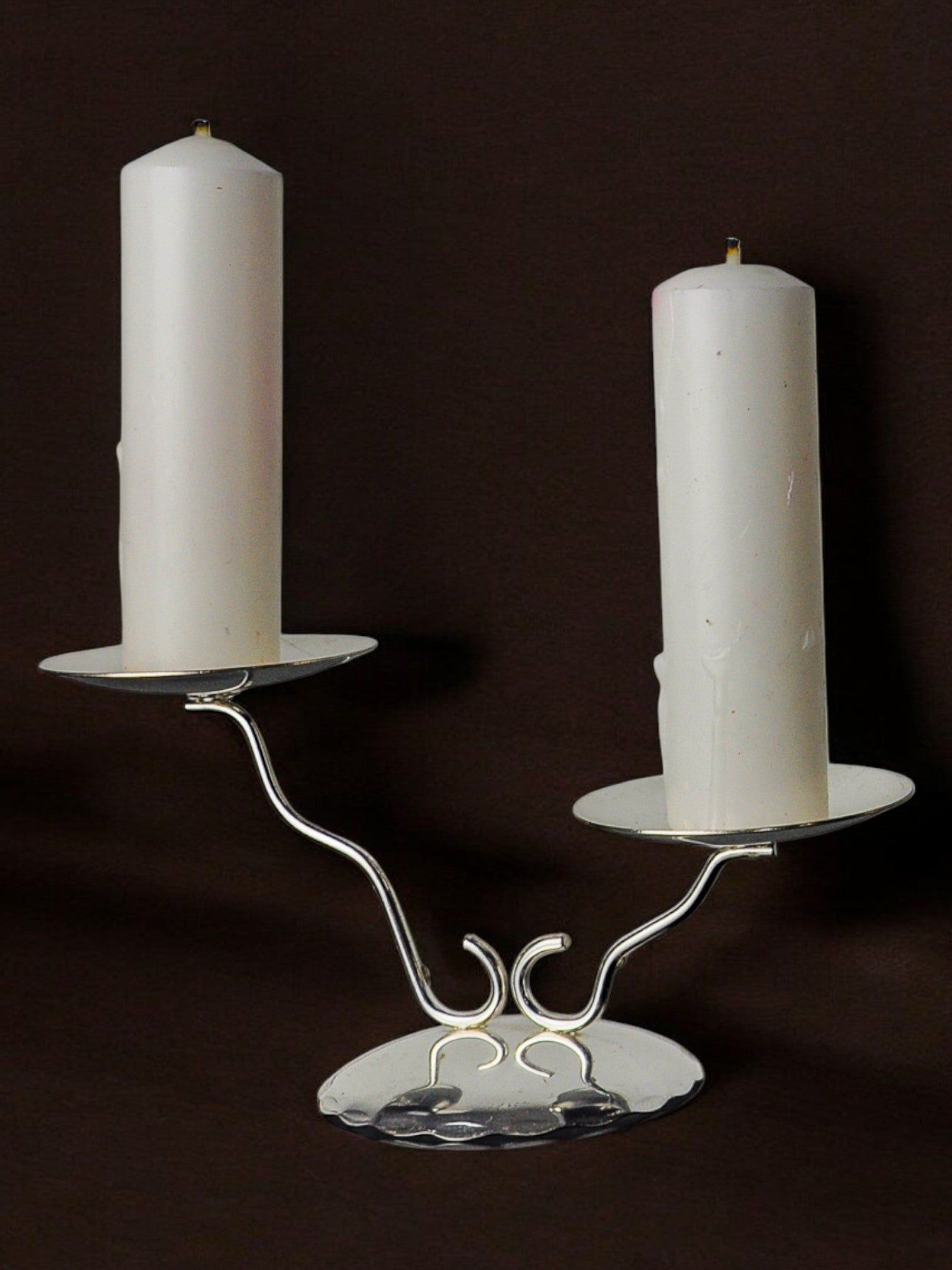 The Malamar Studio Art deco 2-flame candlestick, Spain, 1980, features a silver metal structure with curved arms holding two white pillar candles—ideal for stylish interior decoration.