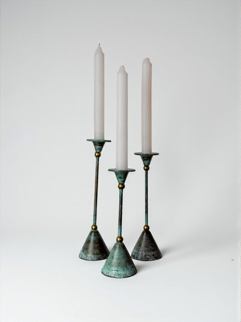 Three oxidized brass candlesticks with white tapers, French 1980s