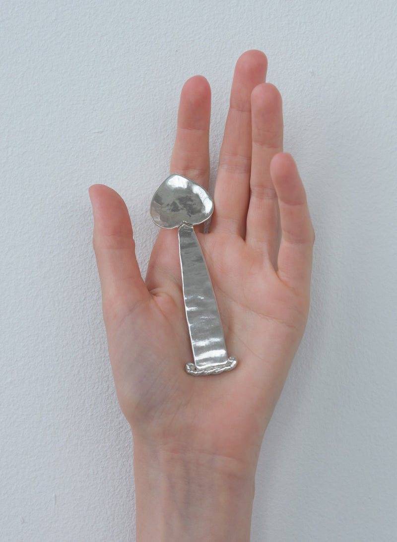 Polished silver Vincent spoon held in palm showing curved design