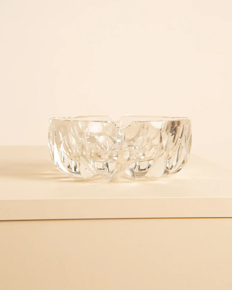 Saint-Louis “Ambassadeur” D120 Ashtray from the 1970s, by Treaptyque, in clear crystal with intricate leaf-like patterns, placed on a light-colored surface against a beige background.