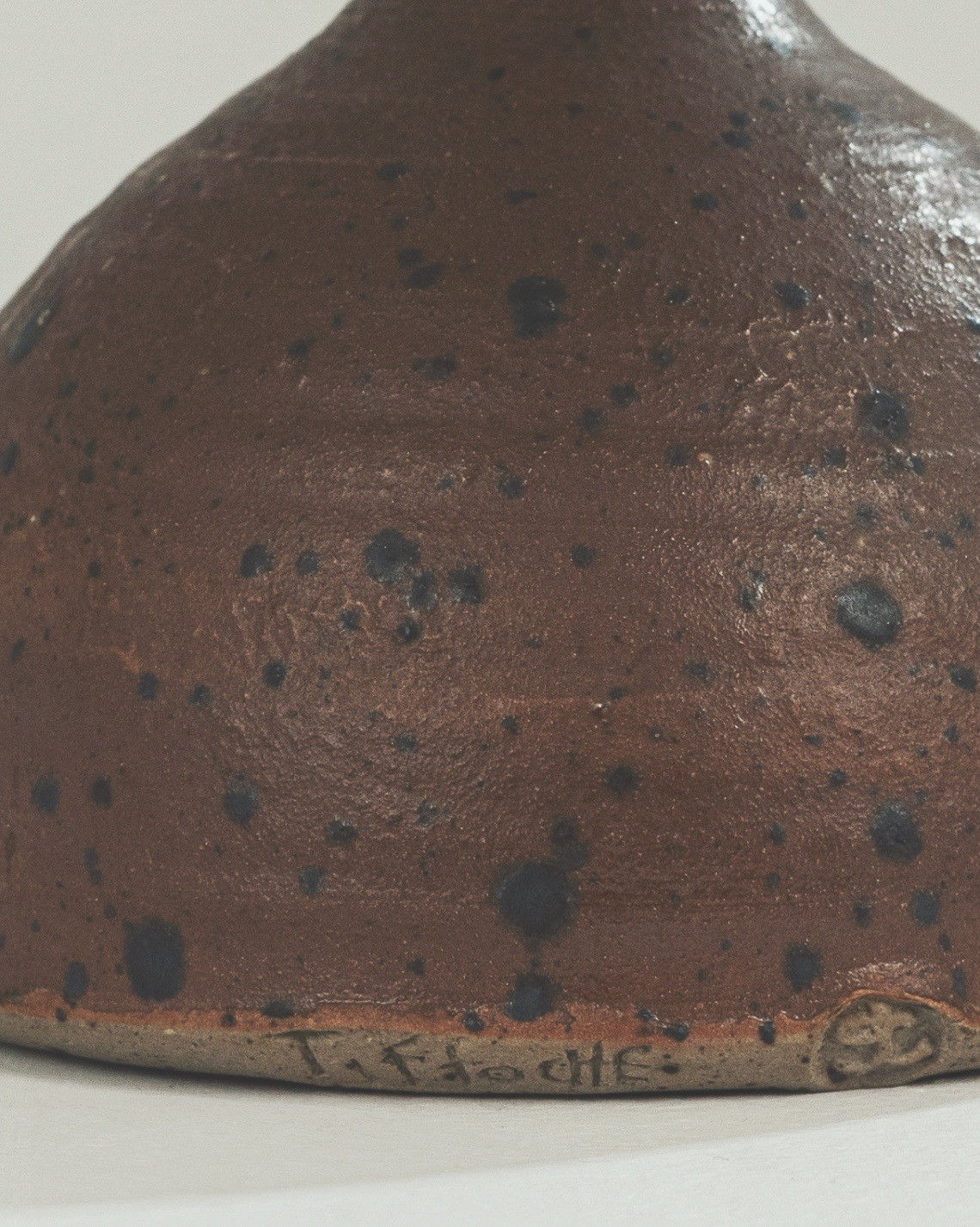 Bottom detail showing artist signature on brown speckled stoneware vase