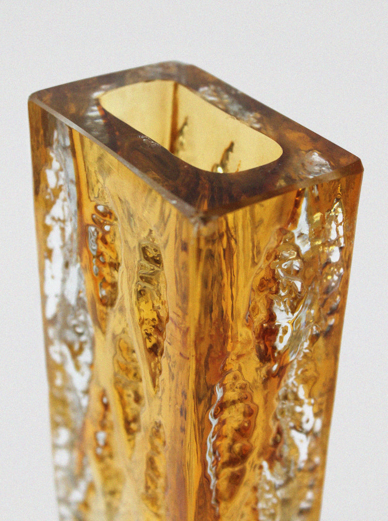 Amber crystal vase detail showing textured glass walls and opening