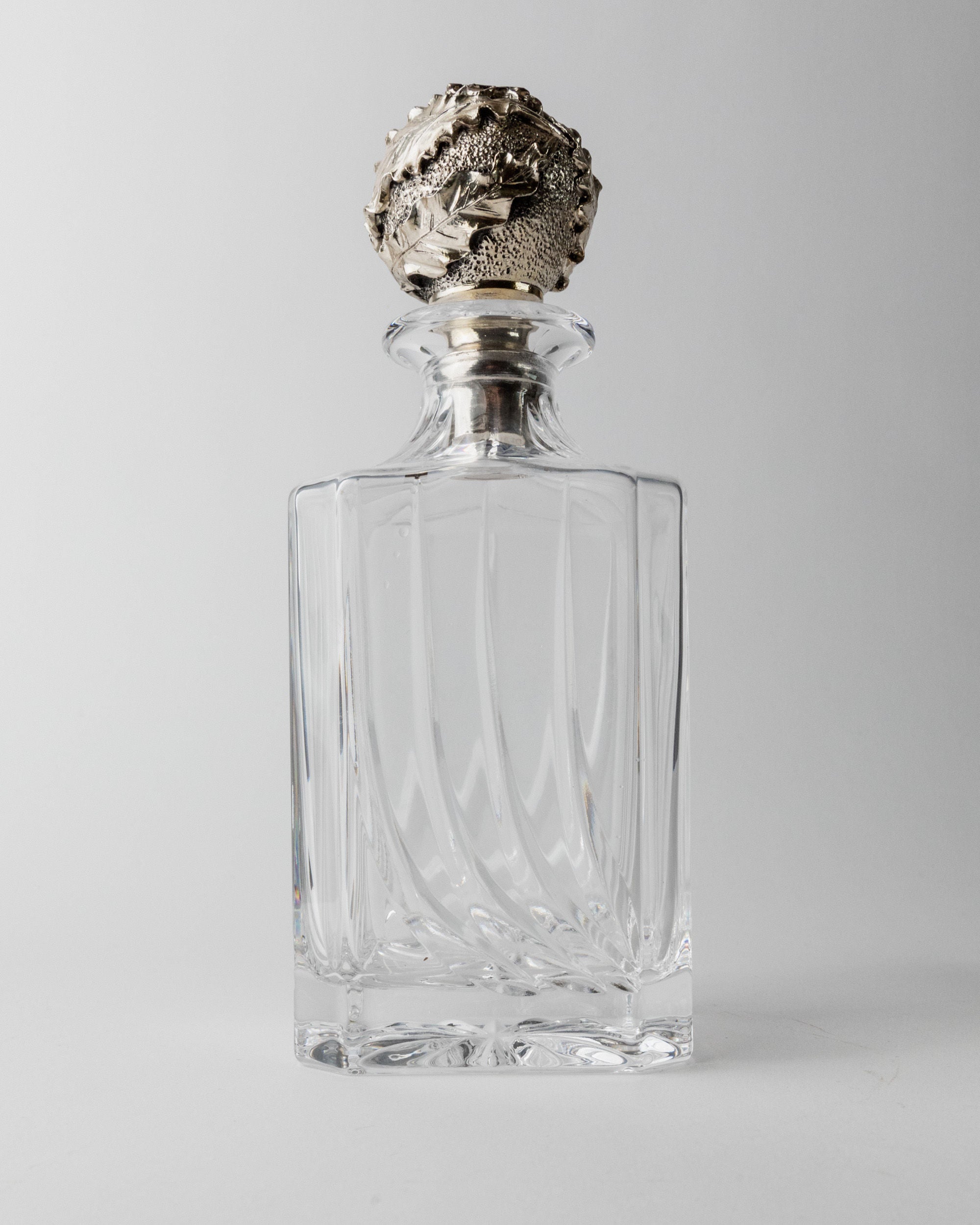 Crystal glass decanter with ornate silver stopper detail view