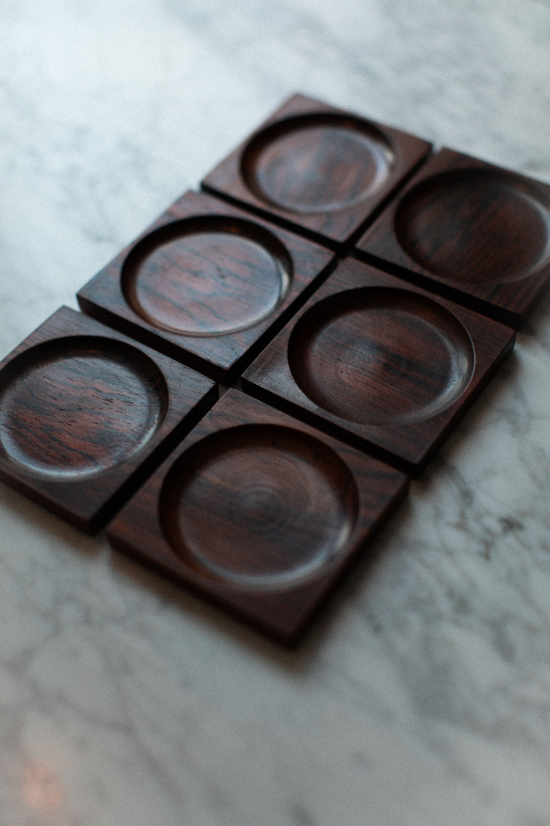 Alt text: Handcrafted wooden coasters with intricate designs for protecting your tables