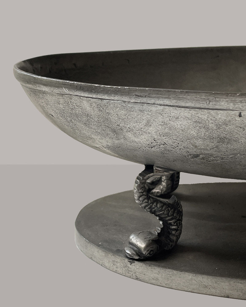 Close-up detail of pewter bowl's serpent pedestal base support