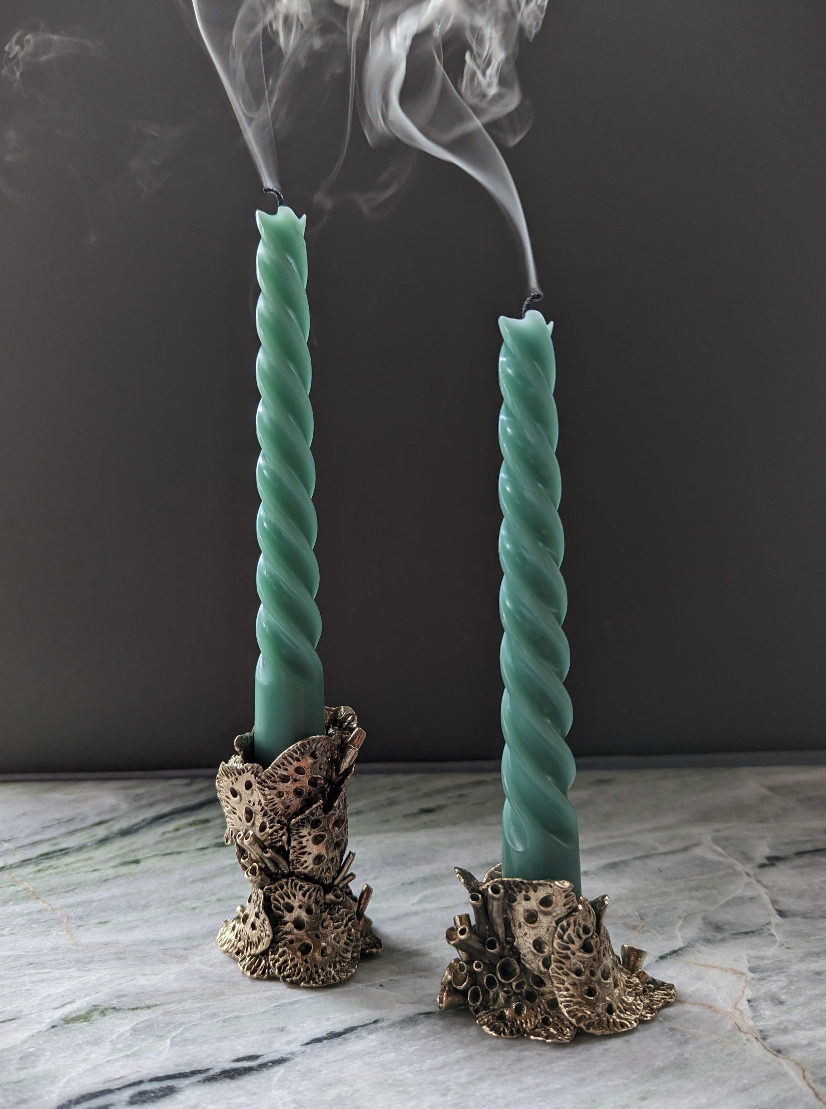 Close-up of bronze lichen candle holders with intricate design