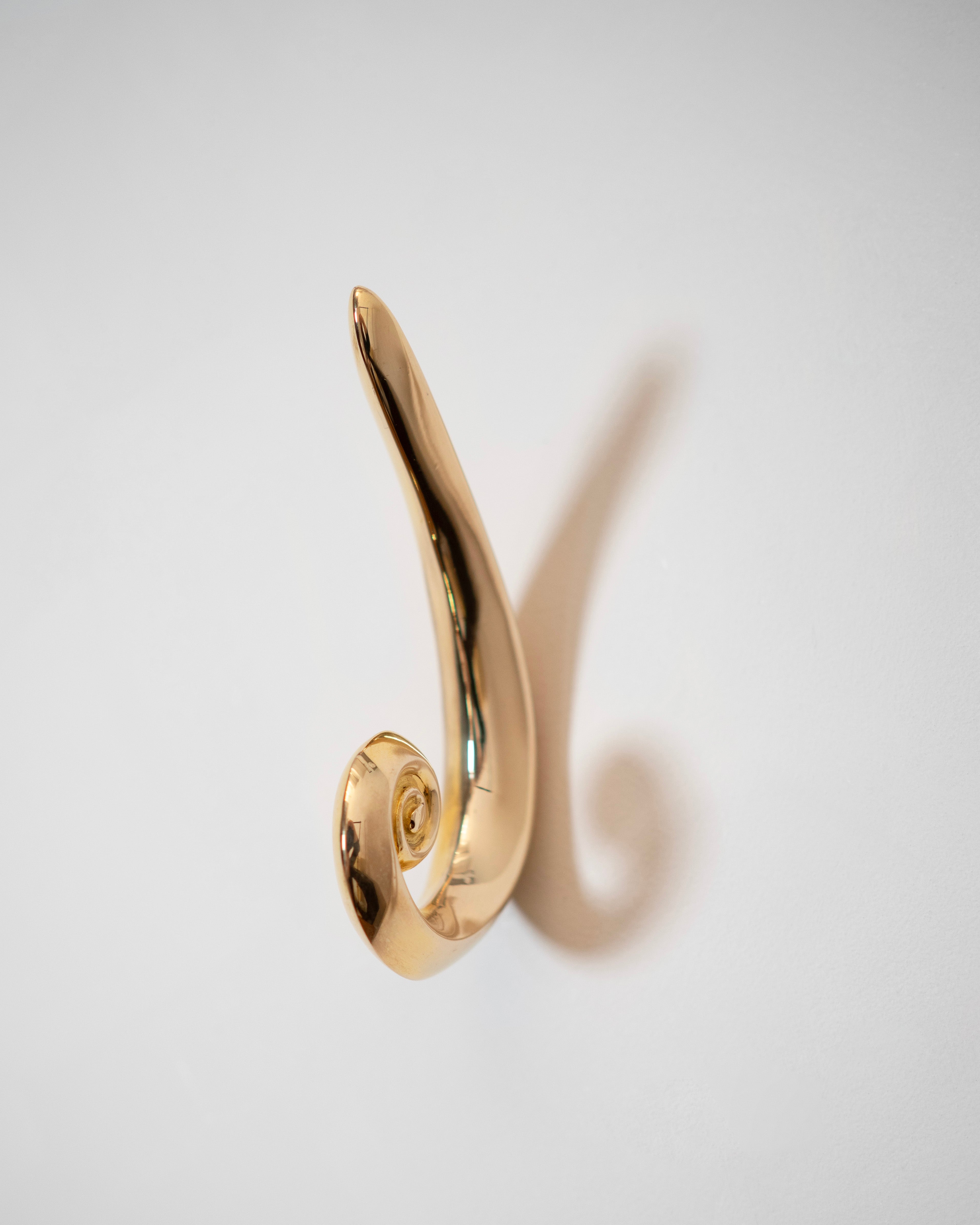 The Noelle Hook - Brass by Hein Studio, featuring a gold sandcasted finish, displayed on a white background.