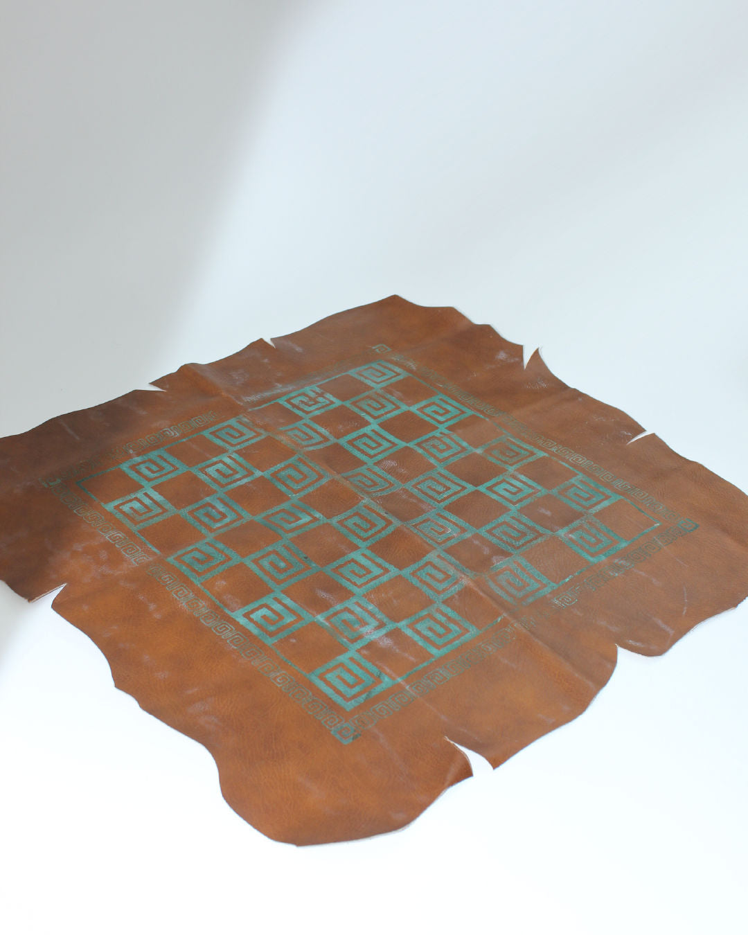 Brutalist chess board with turquoise geometric pattern on leather