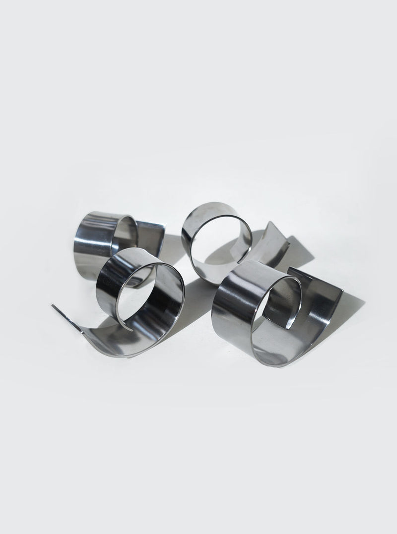 Set of polished stainless steel spiral napkin rings for elegant table setting