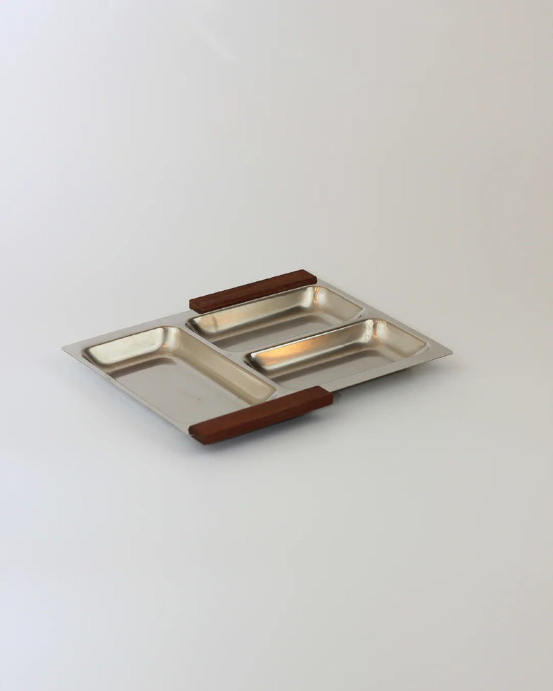 The Stainless Steel Danish Tray 70s by Boga Avante Shop boasts a sleek stainless steel design with three rectangular compartments and stylish teak wood handles on the shorter sides, set against a plain light background.