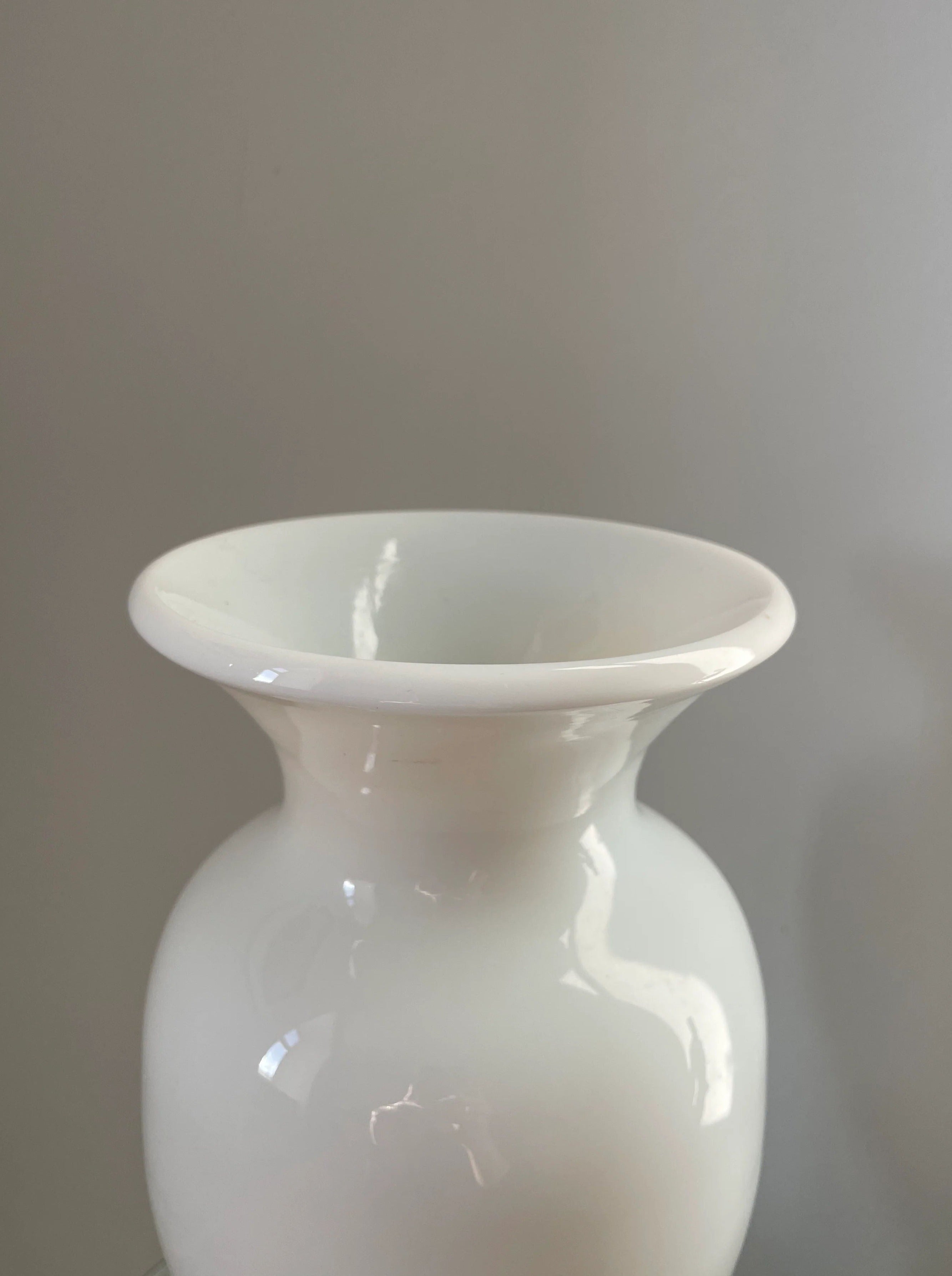 Tall white glass vase with flared opening and delicate frosted texture