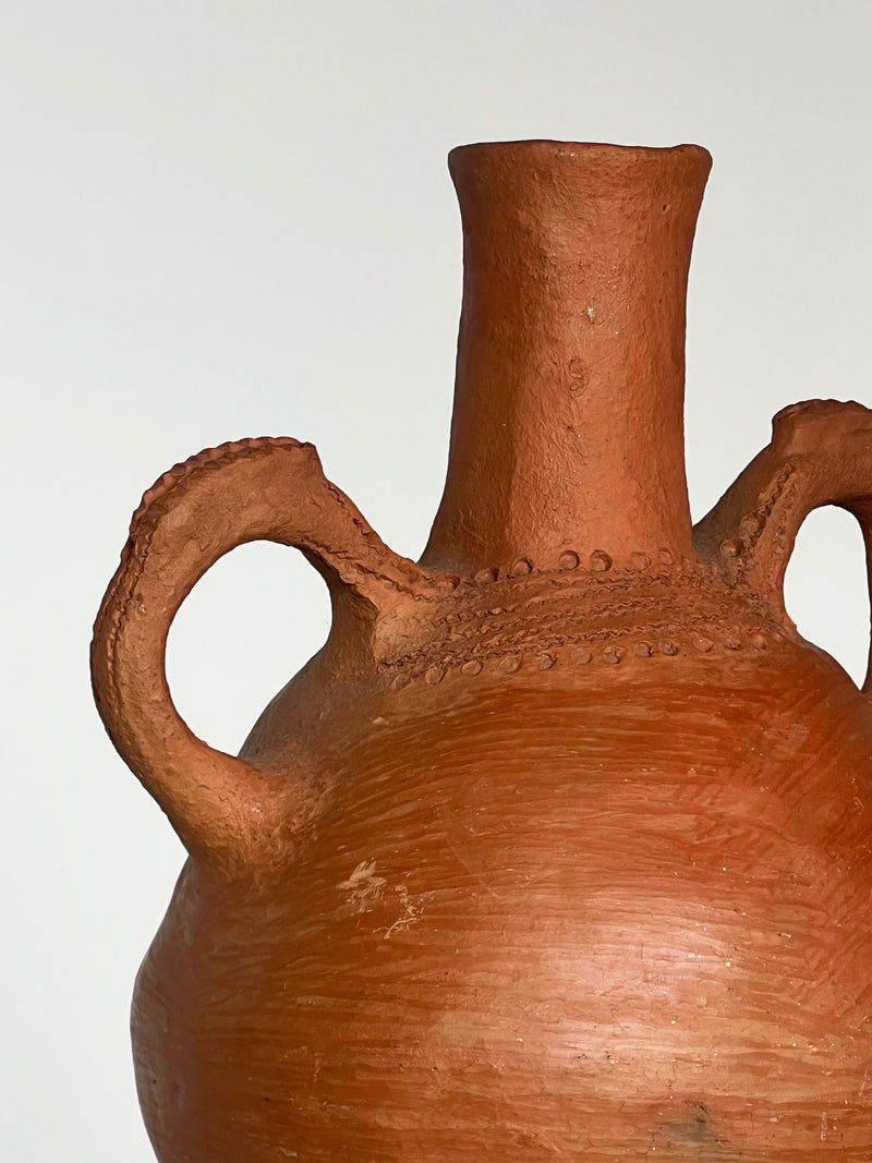 Terracotta vessel detail showing textured handles and neck