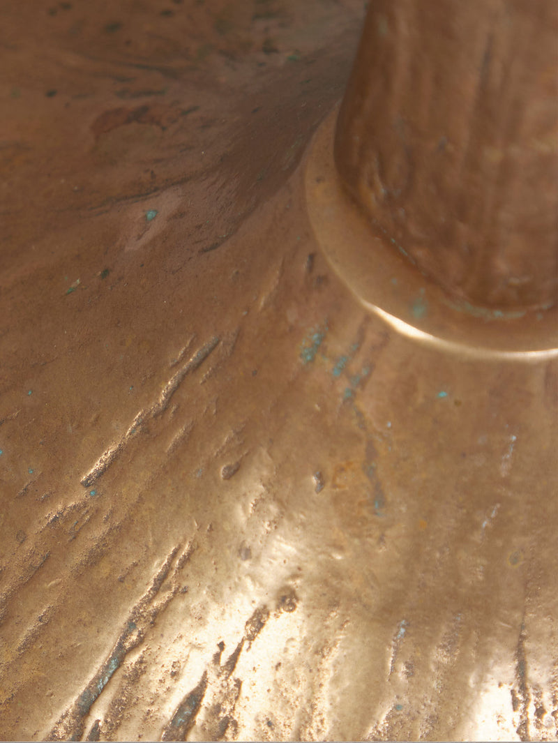 Close-up of a weathered bell bronze surface, like the Floor Standing Brutalist Candleholder by Tobias Harjes from RELIC LONDON. The circular base features irregular grooves and greenish patina, evoking age and corrosion.