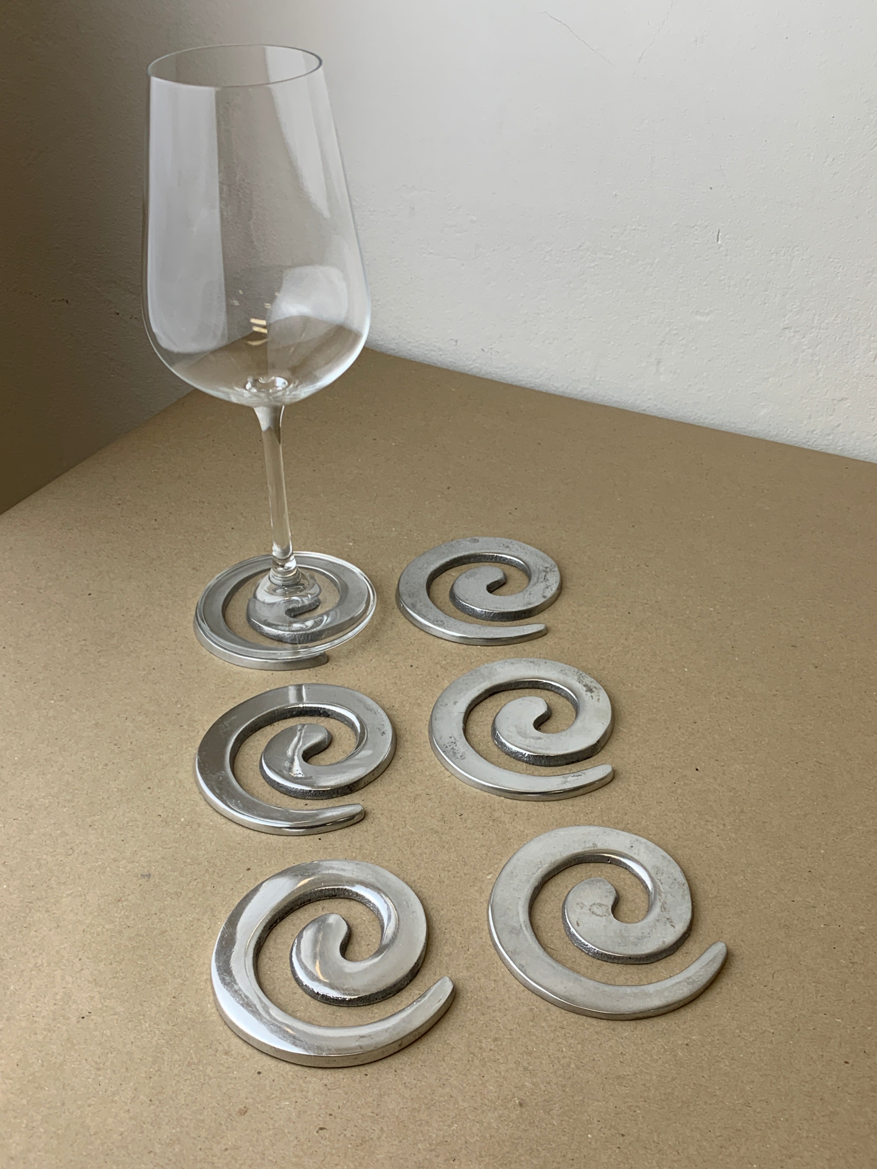Aluminum spiral coasters with wine glass lifestyle detail