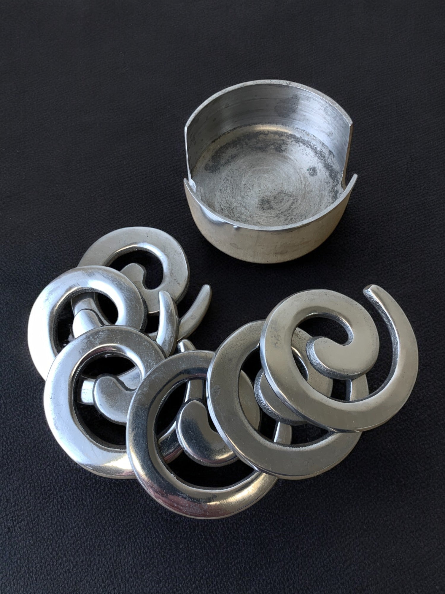 Set of six biomorphic aluminum coasters with storage bowl detail