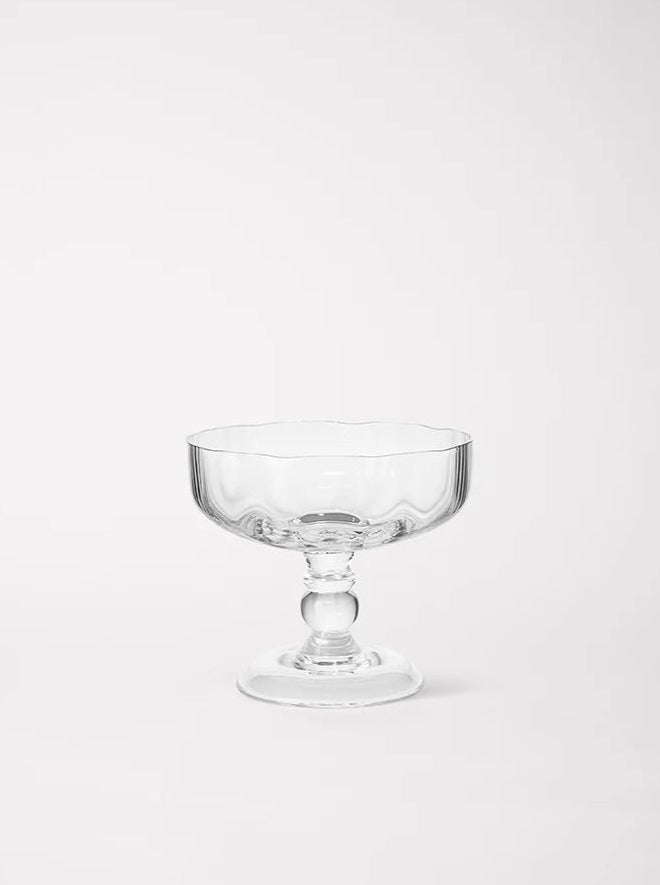 An empty, clear Akua Objects Alban Champagne Glass sundae dish on a white background. The dish features a simple, elegant design with a stemmed base.