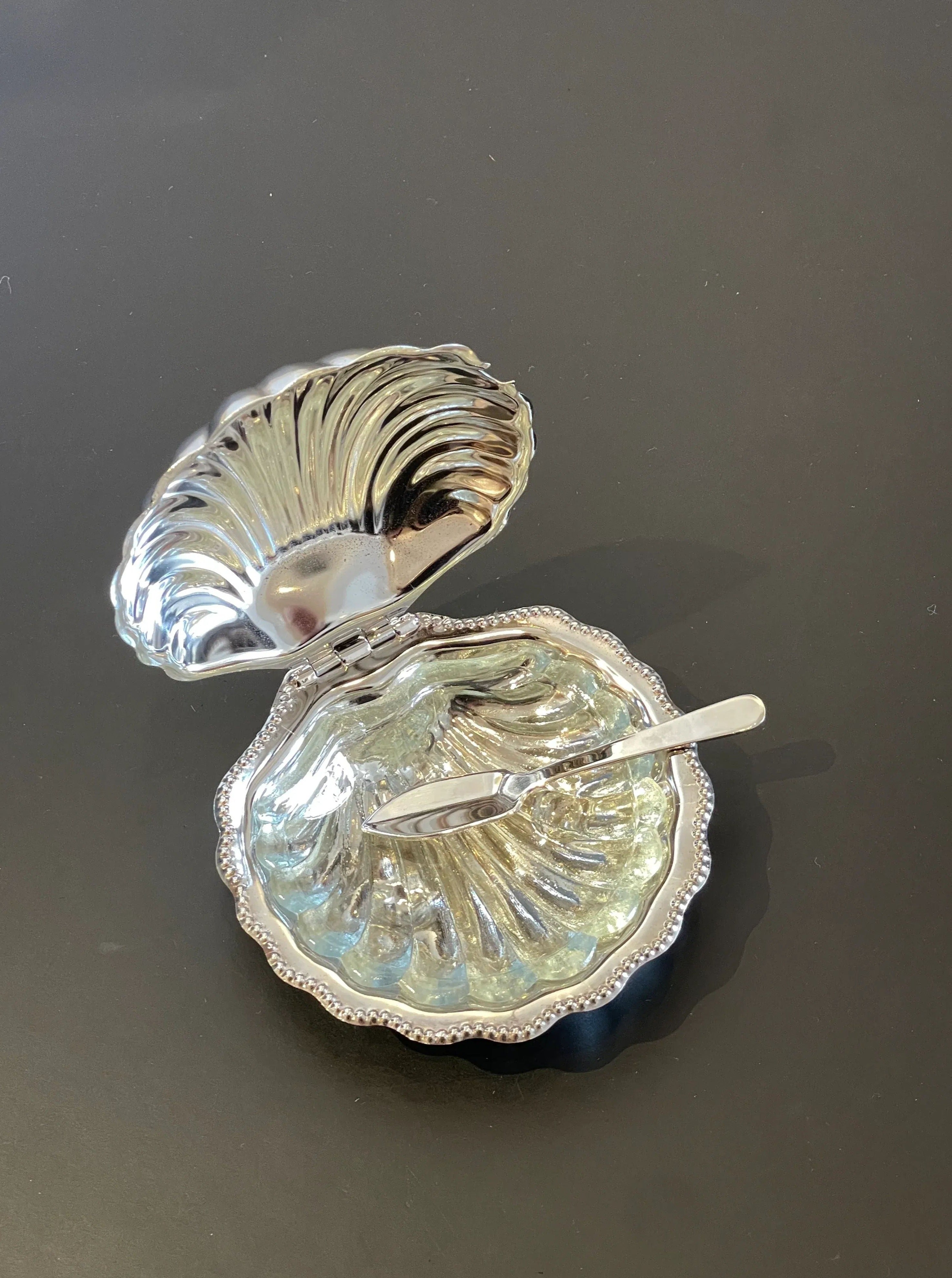 Silver plated shell butter dish with intricate design and smooth finish
