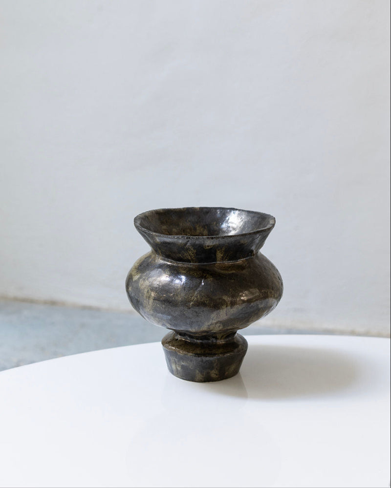 Dark obsidian stone vase with curved silhouette and wide rim opening